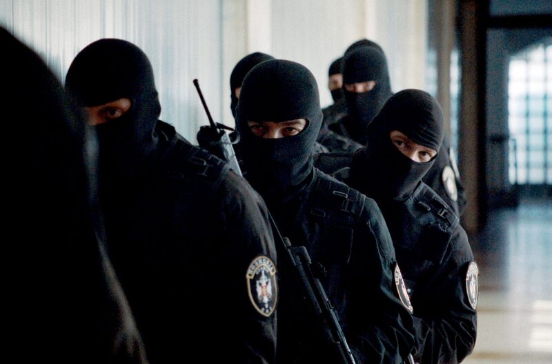 Eine Spezialeinheit der Polizei hält sich bereit, als Vertreter der „Roten Barette“ ins Polizeipräsidium bestellt werden. – Bild: This and That Productions