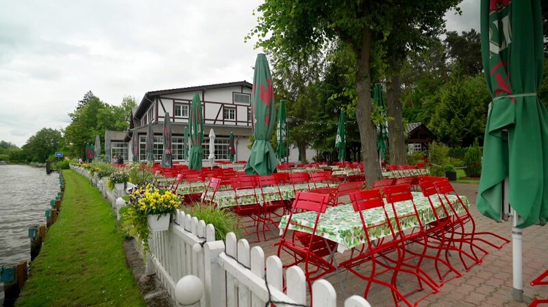 Genießen und Verweilen unter schattigen Bäumen. Ein Besuch in Berlins Gartenlokalen. Was macht sie so beliebt? 30 gute Tipps für einen schönen Sommerabend. – Biergarten mit Fähre – Bild: rbb/​Arne Jannsen