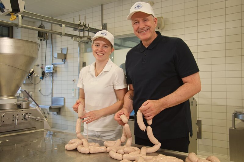 An die Königsdisziplin des Wurstmachens traut sich Alexander Herrmann (rechts): Er macht bayerische Weißwurst. Mit der Weißwurstkönigin höchstpersönlich, Metzgermeisterin Elisabeth Schadl. Sie zeigt ihm in der Fleischerschule in Augsburg alle Kniffe von der Herstellung bis zum Genuss des Klassikers mit Brezen und süßem Senf. Weiteres Bildmaterial finden Sie unter www.br-foto.de. – Bild: Frank Johne /​ BR