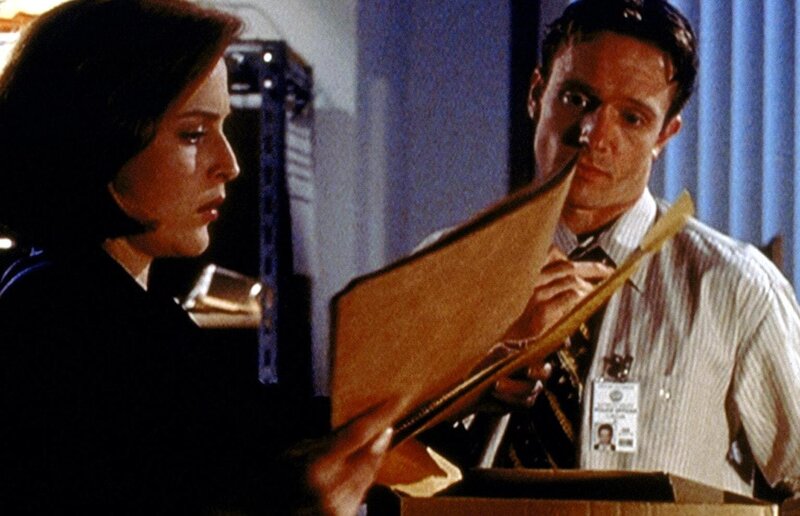 Dana Scully (Gillian Anderson, l.) nimmt Einsicht in die Unterlagen zu dem Fall der Familie Sim. – Bild: Twentieth Century Fox Film Corporation