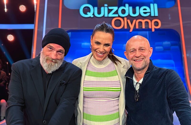 Moderatorin Esther Sedlaczek (M.) mit den Kandidaten des Teams „Spaß“: Torsten Sträter (l.) und Jürgen Vogel (r.). – Bild: ARD/​ITV Studios