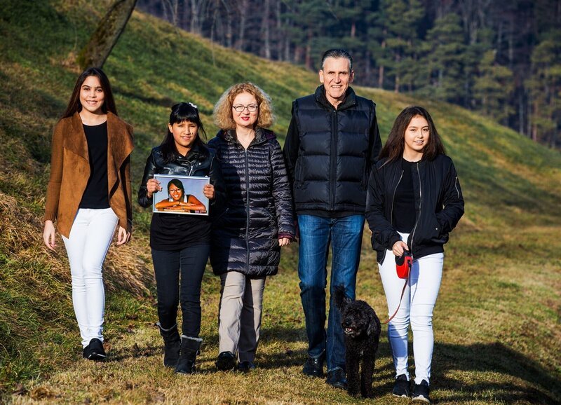 SRF bi de Lüt Familiensache Folge 4 Familie Hunkeler Flück: Paulina Gongora, Yuri Hunkeler mit einem Bild von Carmela Hunkeler, Denise Hunkeler Flück, Viktor Hunkeler und Atalia Hunkeler mit Hund Theres – Bild: SRF