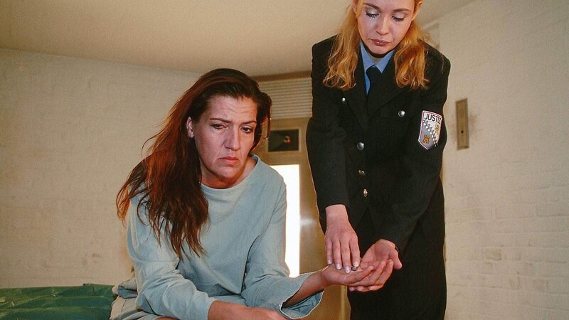 Walter (Katy Karrenbauer, l.) sitzt im Bunker. Bea (Sonia Farke) kommt dazu und gibt ihr das Feuerzeug. – Bild: RTL Deutschland