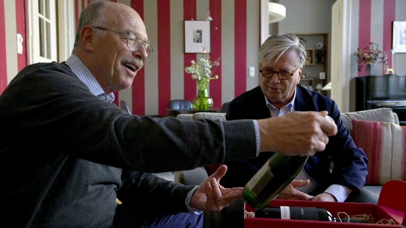 Tourismusmanager Christian Piller präsentiert Hotelier Max Eidlhuber eine originale Glykol-Weinflasche. – Bild: ORF/​Kurt Mayer Film