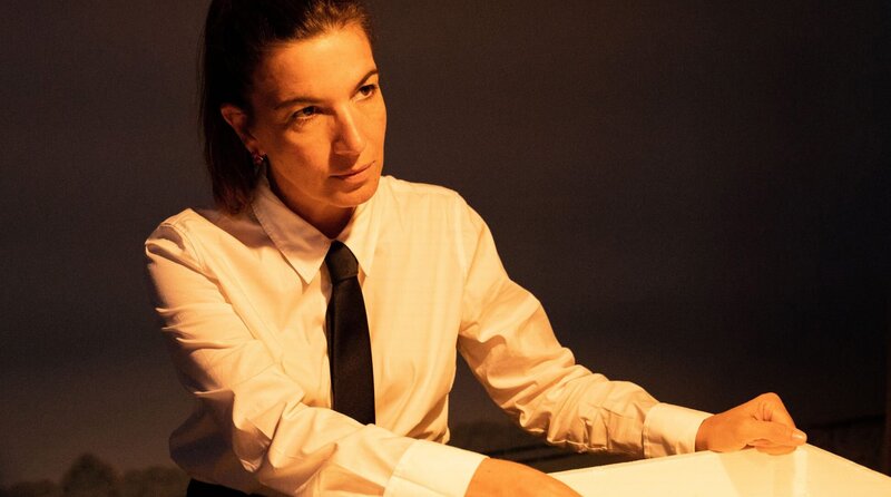 Sobral (Lúcia Moniz) wirft einen angespannten Blick zu Lino – wird er sich an den Plan halten? – Bild: ARD Degeto/​Mariella Koch