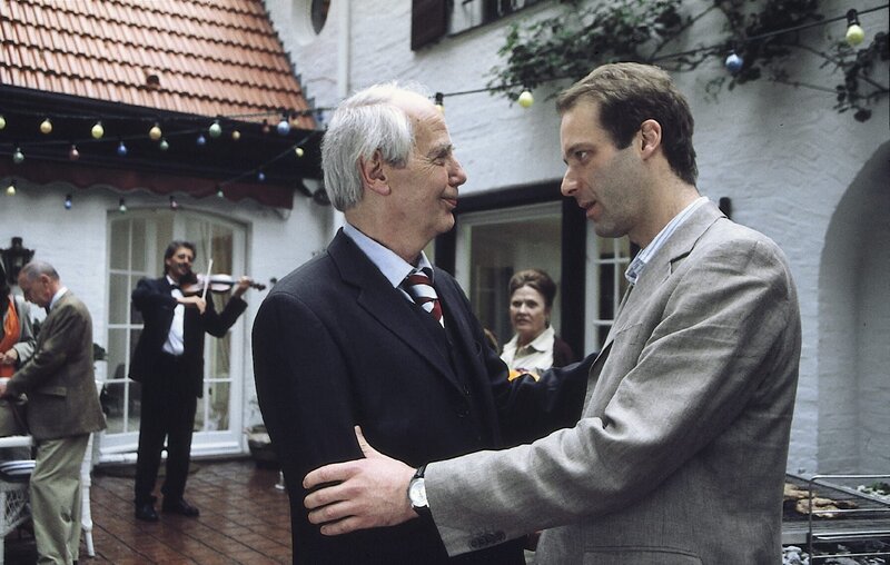 Dr. Karl Lederle (Joachim Bliese, M.) freut sich über die Geburtstagsglückwünsche seines Sohnes Rudolf (Michael Wenninger, r.), während seine Ehefrau Kreszenz (Cordula Trantow, 2.v.r.) befürchtet, dass das Fest nicht so friedlich ablaufen wird, wie erhofft. – Bild: ZDF/​Daniela Incoronato