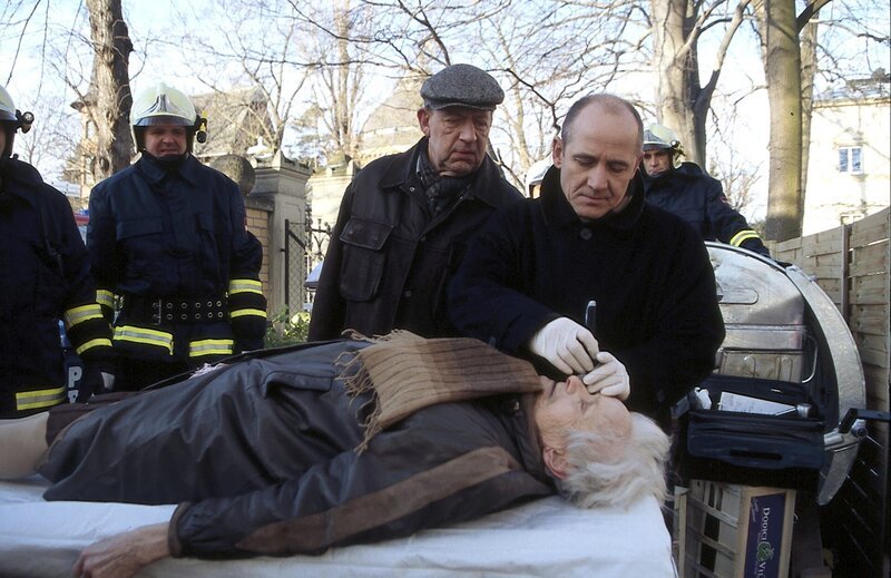 Dr. Robert Kolmaar (Ulrich Mühe, r.) und Kommissar Joe Hoffer (Jörg Gudzuhn, M.) werden zu einer alten Frau gerufen, die in einem Müllcontainer starb. – Bild: ZDF Dr. Robert Kolmaar (Ulrich Mühe, r.) und Kommissar Joe Hoffer (Jörg Gudzuhn, M.) werden zu einer alten Frau gerufen, die in einem Müllcontainer starb. – Bild: ZDF