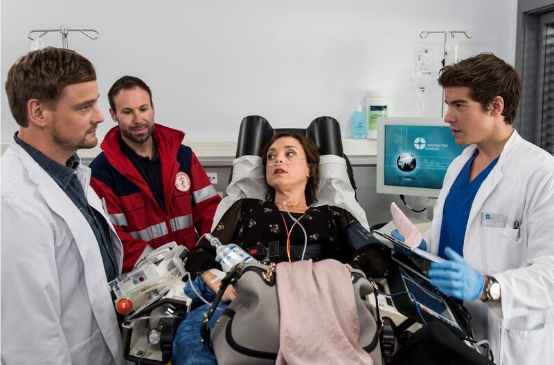 Die Besitzerin eines Fitnessstudios, Katja Becker (Dominique Chiout, 2. von rechts) wird ins Johannes-Thal-Klinikum gebracht. Die Ärzte Dr. Marc Lindner (Christian Beermann, links) und Ben Ahlbeck (Philipp Danne, rechts) diagnostizieren einen Herzinfarkt (mit Komparse, 2. von links). – Bild: ARD/​Jens Ulrich Koch