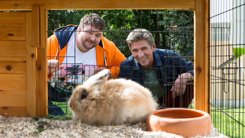 Ferien in Bärstadt: Fritz Fuchs (Guido Hammesfahr, r.) will mit Keks eine Radtour machen und hofft deshalb, dass er sich nicht um die Kaninchen und den Garten von David (Daniel Zillmann, l.) kümmern muss. – Bild: ZDF und Zia Ziarno