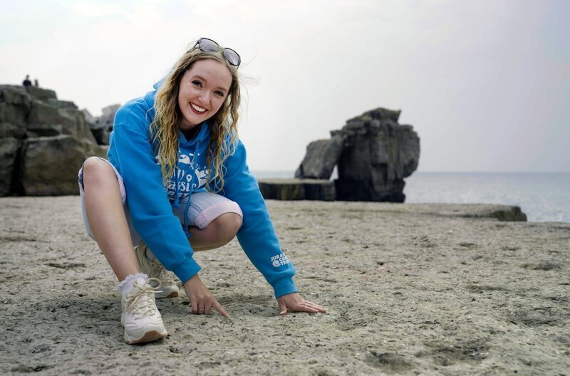 Schon in ihrer Kindheit hat Saskia Elliot Steine am Chesil Beach gesammelt. Inzwischen ist sie Geologin und fasziniert davon, dass entlang der Küste immer noch neue Entdeckungen gemacht werden. – Bild: Susanne Bohlmann