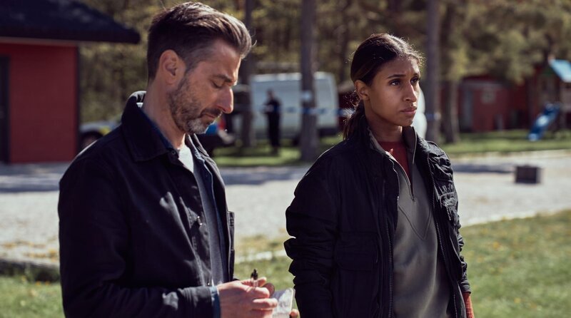 Arvidsson (Peter Perski, li.) und seine Kollegin Sasha (Lola Zackow) befragen Mitglieder des Fussballvereins. – Bild: ARD Degeto/​TV4/​Warner Bros. ITVP/​Cologne Film/​Johan Stjérneus