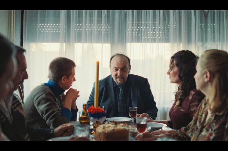 Bei einem Fest gedenken Boris (Ljubomir Bandović, 3.v.r.) und seine Frau Marina (Dolya Gavanski, 2.v.r.) Ljubas und Žarkos. – Bild: This and That Productions