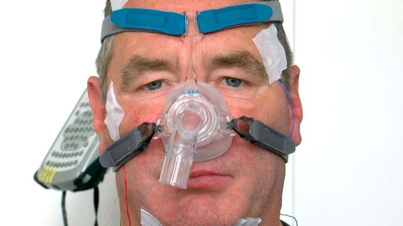Patient mit Schlafapnoe-Maske. – Bild: HR