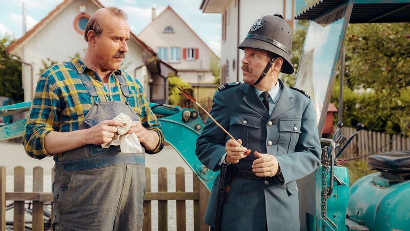 Dem Auge des Gesetzes entgeht nichts: Stefan Kurt als Papa Moll Erich Vock als Wachtmeister Grimm – Bild: SRF/Zodiac Pictures Ltd. Dem Auge des Gesetzes entgeht nichts: Stefan Kurt als Papa Moll Erich Vock als Wachtmeister Grimm – Bild: SRF/Zodiac Pictures Ltd.