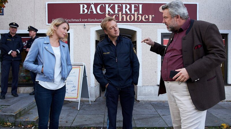 Die Kommissare Winter (Vanessa Eckart, l.) und Stadler (Dieter Fischer, r.) ermitteln im Fall des ermordeten Bäckermeisters Schober. Polizeihauptmeister Mohr (Max Müller, M.) bringt sie auf den aktuellen Kenntnisstand. – Bild: ZDF