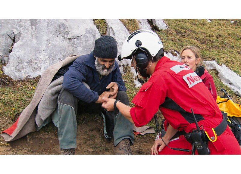 SF bi de Lüt Hüttengeschichten Folge 3 Hilfe aus der Luft: Nach der Landung kümmert sich der Rega-Notarzt sofort um den verletzten Fredi Schleiss, den Vater der Hüttenwartin Megi. – Bild: SRF