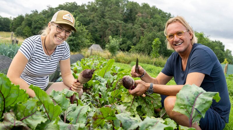 Auf dem Gelände des Scheuerhofs haben sich Lara Rebmann (l) und Arved Meinzer einen Traum erfüllt: Mit ihrer „Vielfaltsgärtnerei“ versorgt das Paar seit 2020 ihre Kunden mit frischem Gemüse und Kräutern in Abo-Kisten. – Frank Buchholz mit Lara Rebmann – Bild: WDR/​Melanie Grande