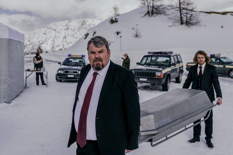 Tschugger Staffel 1 Regie: David Constantin und Leandro Russo Produktion: Shining Film AG Kamera: Rafael Kistler Drehbuch: Johannes Bachmann, Arnold B. Bucher, David Constantin, Rafael Kistler, Leandro Russo Folge 3 Hauptmotiv 4 Keine Toten für den Bestatter: Mike Müller als Luc Konrad (vorne) – Bild: SRF/​Dominic Steinmann