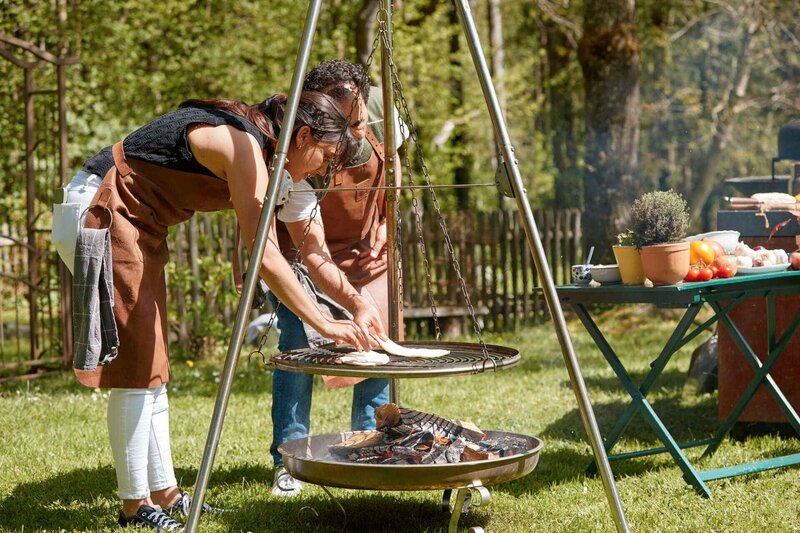 Ivana und Adnan wenden das Fladenbrot am Schwenkgrill. – Bild: Marian Mok /​ BR, Yalla Productions GmbH /​ BR/​Yalla Productions GmbH/​Marian Mok