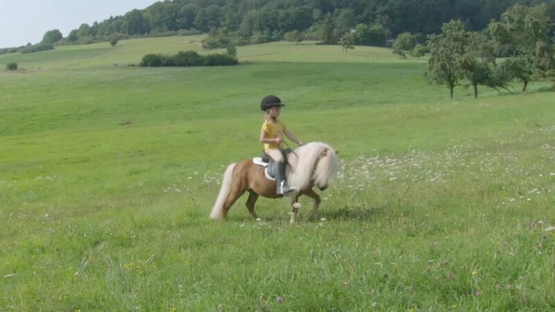 Laura trainiert mit ihrem Mini-Shetty auf dem Reitplatz das Springen. – Bild: WDR/​Die Sendung mit dem Elefanten