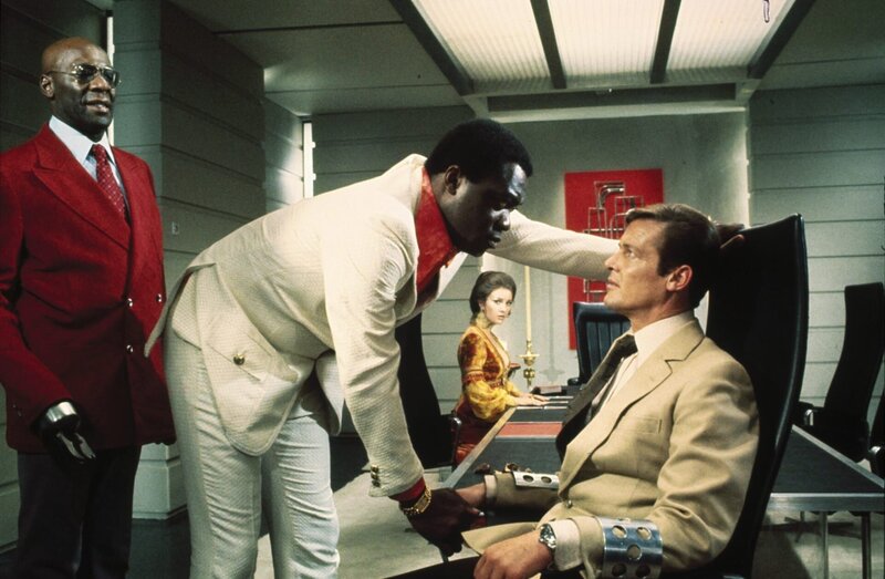 James Bond (Roger Moore) befindet sich in der Gefangenschaft von Mr. Big (Yaphet Kotto), Solitaire (Jane Seymour, im Hintergrund)) überlegt, wie sie ihm helfen kann. – Bild: port.hu
