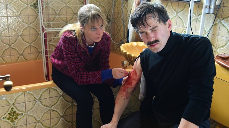 Angelika Flierl (Bernadette Heerwagen) leistet bei ihrem verletzten Entführer (Franz Dinda) erste Hilfe und näht eine Wunde. – Bild: ZDF