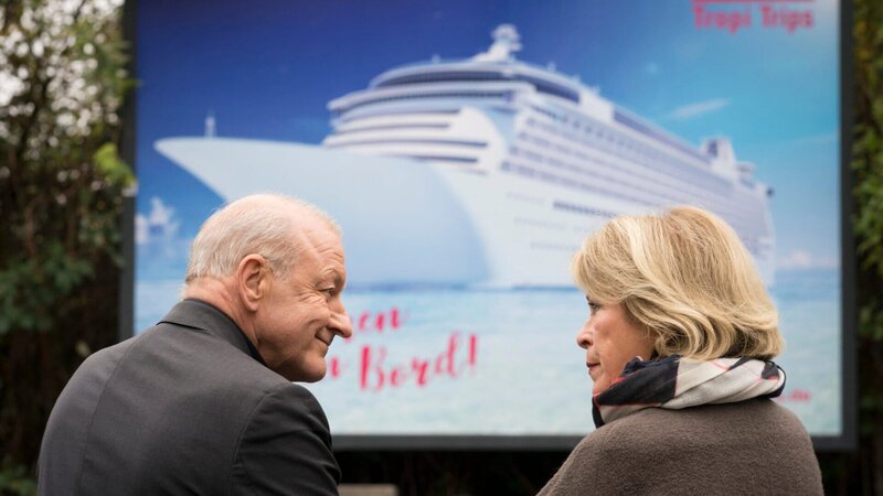 Georg Wilsberg (Leonard Lansink) und Anna Springer (Rita Russek) schmieden Pläne, auf einem Kreuzfahrtschiff nach Panama zu verreisen. – Bild: ZDF