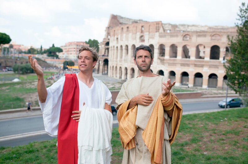 Checker Tobi (links) und Fabio, verkleidet als Senatoren, vor dem Colosseum in Rom. – Bild: BR/​megaherz gmbh/​Hans-Florian Hopfner