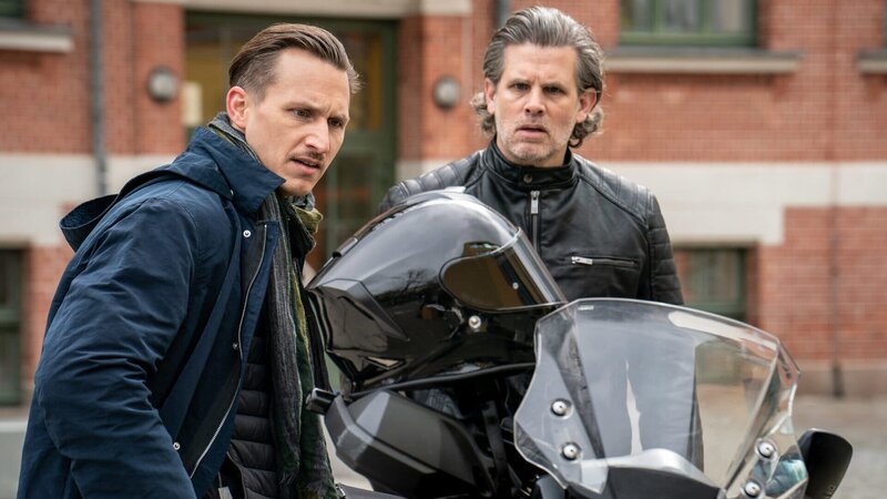 Da der Attentäter auf einem Motorrad unerkannt entkommen konnte, schaut sich Moritz Brenner (Johannes Hendrik Langer, l.) die Maschine des Lehrers Dr. Andreas Willhoff (Steffen Groth, r.) ganz genau an. – Bild: ZDF