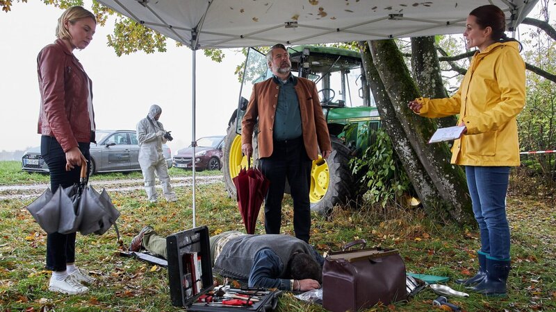 Pathologin Mai (Sina Wilke, r.) erläutert den Kommissaren Stadler (Dieter Fischer, M.) und Winter (Vanessa Eckart, l.), dass das Opfer (Komparse) aus der Ferne erschossen wurde. Im Hintergrund: Spurensicherer (Alexander Vitzthum). – Bild: ZDF