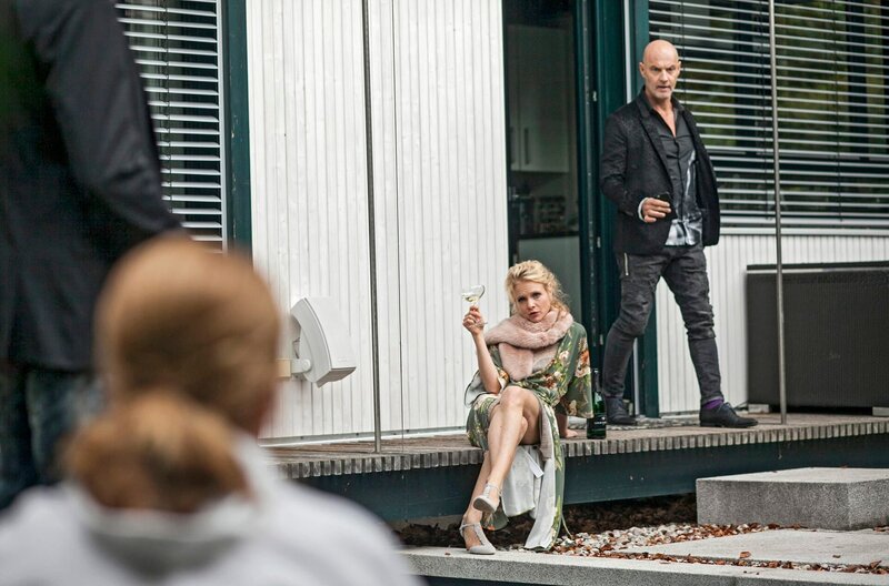 Zur beschwipsten Hausherrin Sandra Joschek (Friederike Ott, 2.v.l.) gesellt sich ihr Mann Bert (Simon Licht, r.). Sie nimmt dank des Champagners, den Leichenfund gelassen hin. – Bild: ARD/​TMG/​Chris Hirschhäuser