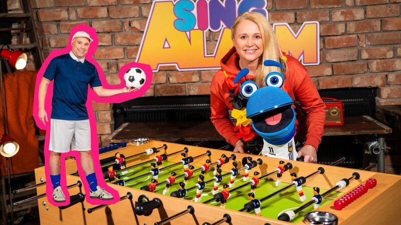 Singa und das SingDing sind voll im Fußballfieber: Wer wohl den Pokal gewinnt? Für Tobi Polar ist es auf jeden Fall „Die 11“ – denn die hält immer zusammen! – Bild: ZDF/​Tim Bornemann