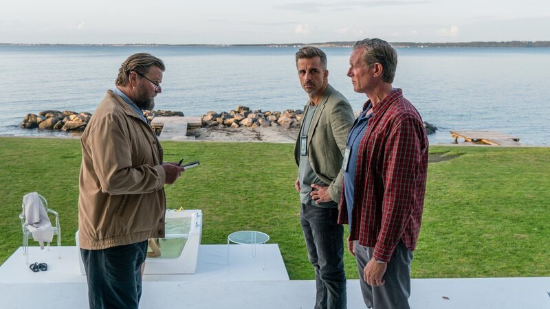 Svend (Peter Gantzler, l.) war als erstes am Tatort und berichtet seinen Kollegen Dan (Peter Mygind, r.) und Flemming (André Babikian, m.) von den bisherigen Erkenntnissen. – Bild: Mike Kollöffel /​ ZDF