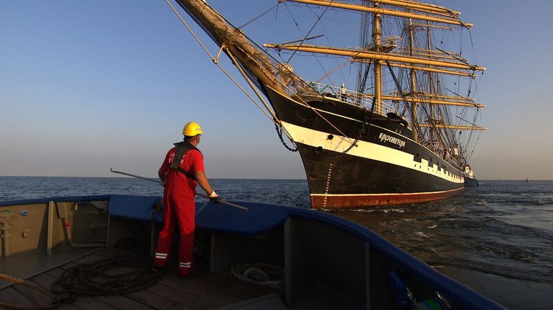 Der historische Großsegler „Kruzensthern“ nähert sich dem Schlepper auf der Ostsee vor Rostock-Warnemünde. Im richtigen Moment geht die Leine über und die Schleppverbindung wird aufgebaut. – Bild: NDR/Hanse TV Der historische Großsegler „Kruzensthern“ nähert sich dem Schlepper auf der Ostsee vor Rostock-Warnemünde. Im richtigen Moment geht die Leine über und die Schleppverbindung wird aufgebaut. – Bild: NDR/Hanse TV