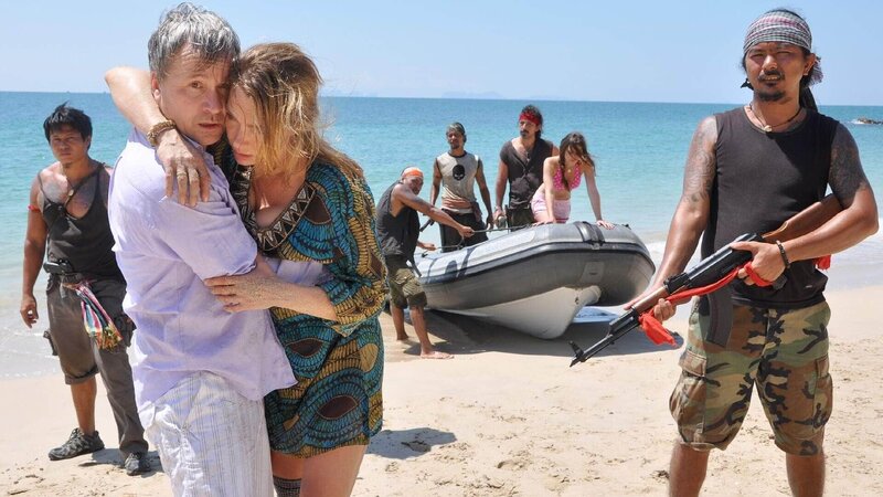 Die Piraten haben eine einsame Bucht angesteuert. Gerd Kramer(Thomas Darchinger) mus seine Frau Marianne ( (Aglaia Szyszkowitz) tragen, die nicht mehr laufen kann und zusammen bricht, während Jack Sparrow (John Polwannapa, 3.v.re.) Tochter Lena (Xenia Assenza) im Schlauchboot im Auge behält. – Bild: TVNOW /​ Aki Pfeiffer