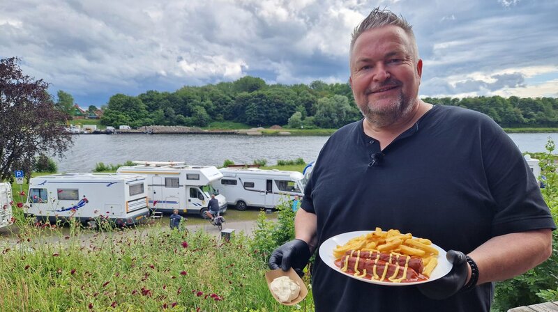 Imbisschef Holger versorgt auch die Camper mit Currywurst. – Bild: NDR/​Joker Pictures GmbH