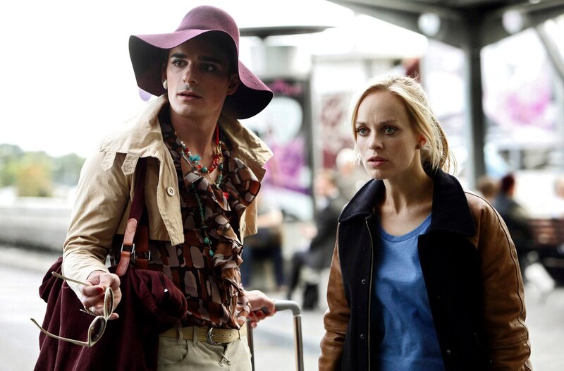 Julia Klug (Friederike Kempter, r.) holt ihre Freundin Karla (Hannes Wegener, l.) am Flughafen ab und wird Zeugin eines Kofferdiebstahls. – Bild: NDR/​ARD/​Daniela Incoronato