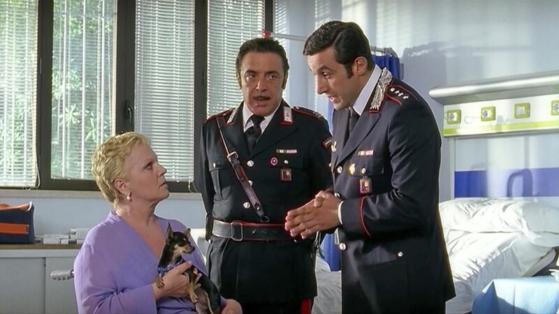 Capitano Anceschi (Flavio Insinna, r.) und Maresciallo Cecchini befragen den zickigen Opernstar Giulia Baldeschi (Katia Ricciarelli, l.). – Bild: Bibel TV