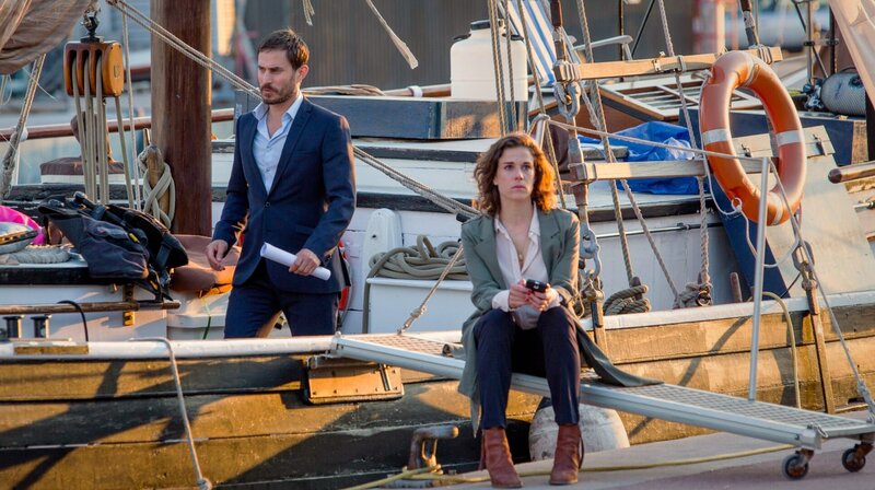 Xavi (Clemens Schick) und Fina (Anne Schäfer) ermitteln im Hafen in einem rätselhaften Mordfall. – Bild: Degeto /​ Dreamtool Entertainment/​L /​ ORF /​ Betafilm