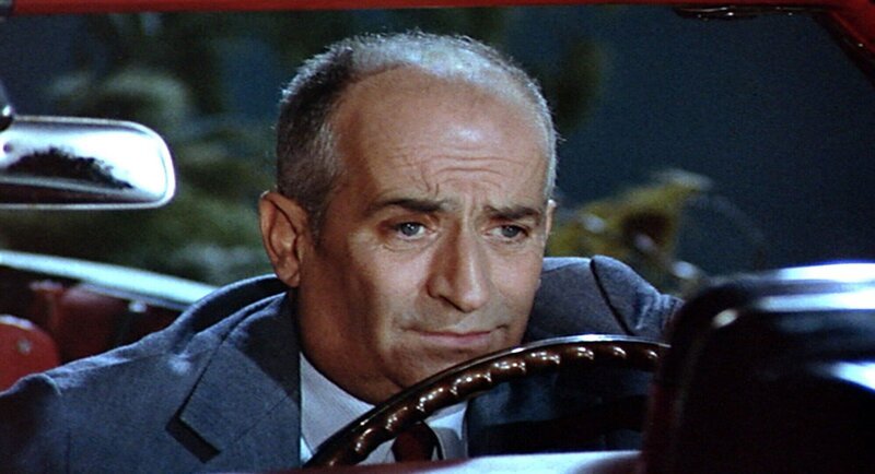 Henri (Louis de Funes) befindet sich in einer fast ausweglosen Situation: Hoch über dem Meer hängt er mit seinem Wagen in einer Pinienkrone. – Bild: RTL