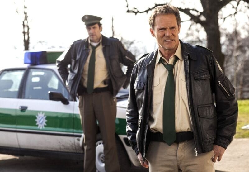 Hubert (Christian Tramitz, rechts) und Staller (Helmfried von Lüttichau) wollen die Senioren-WG vernehmen. Als sie auf dem Hof ankommen, spielen diese gerade Tischtennis. – Bild: port.hu