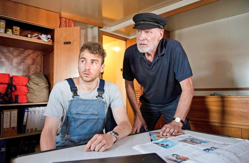 Kapitän Dresen (Rüdiger Kuhlbrodt, r.) und sein Mitarbeiter Anton Gromow (Mark Ortel, l.) haben etwas zu verbergen. – Bild: ORF/​ONE GATE/​ARD/​Thorsten Jander