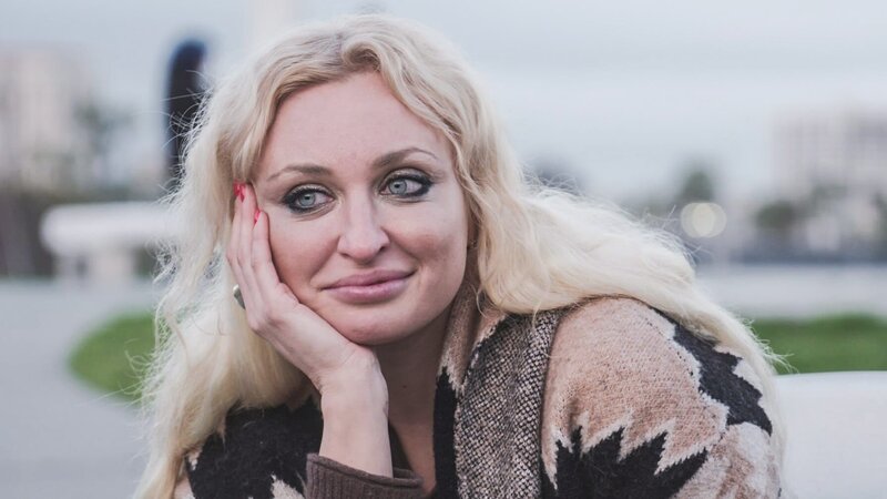 Natalie smiles with her head in her hand while talking to Mike – Bild: Warner Bros. Discovery