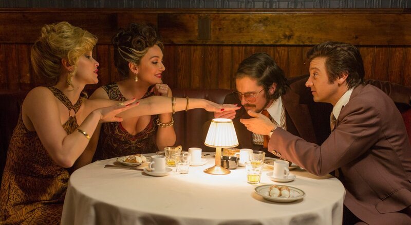 Beim festlichen Diner bricht Rosalyns (Jennifer Lawrence, l.) duftender Nagellack das Eis zwischen Bürgermeister Polito (Jeremy Renner, r.), dessen Gattin Dolly (Elisabeth Rohm, zw. v. l.) Irving (Christian Bale, zw. v. r.) und ihr. – Bild: ZDF und Francois Duhamel