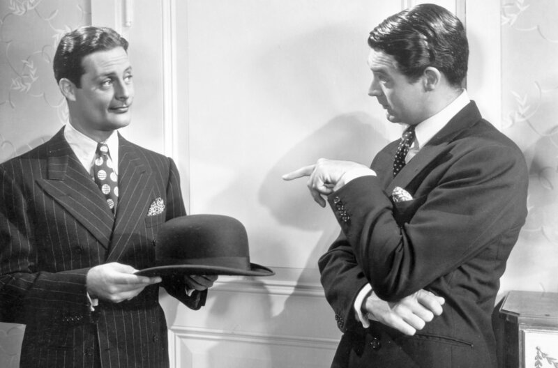 Jerry Warriner (Cary Grant, re.) findet den gutaussehenden Gesangslehrer Armand Duvalle (Alexander D’Arcy, li.) in Lucys Wohnung vor. – Bild: Columbia Pictures Industries, Inc.
