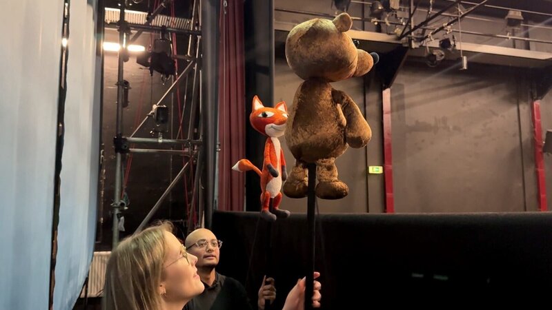 Puppenspieler Jo bringt Lena bei, wie man die Puppen richtig bewegt. – Bild: ORF