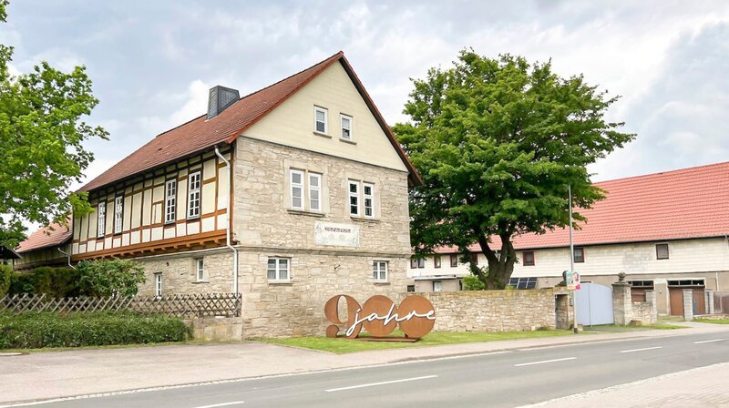 Unübersehbar die große 900 aus Metall am Hüpstedter Ortseingang. Welches Dorfjubiläum gefeiert wird, ist damit klar. – Bild: MDR/​Heike Opitz