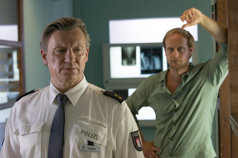Holt den neuen Revierleiter Wolf Haller (Hannes Hellmann, l.) ein Mordfall von vor 25 Jahren ein, in den er als Streifenpolizist involviert war? Der Journalist Elias Vancleef (Gabor Biedermann, r.) ist mit dem damals verurteilten Täter im PK 21 erschienen. Haller soll nach dem wahren Mörder suchen, oder ein Mensch wird getötet. – Bild: ZDF und Boris Laewen (bola)