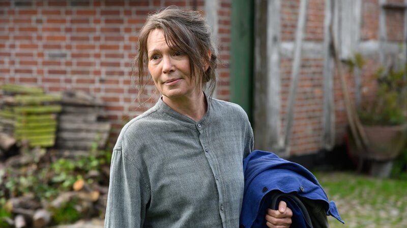 Vera Eckhoff (Iris Berben) freut sich über ihre Nachbarn und will gerade Arbeitskleidung zu ihrer Halbschwester Marlene bringen. Die ist mit ihrer Familie aus Hamburg gekommen, um Kirschen zu pflücken. – Bild: ZDF
