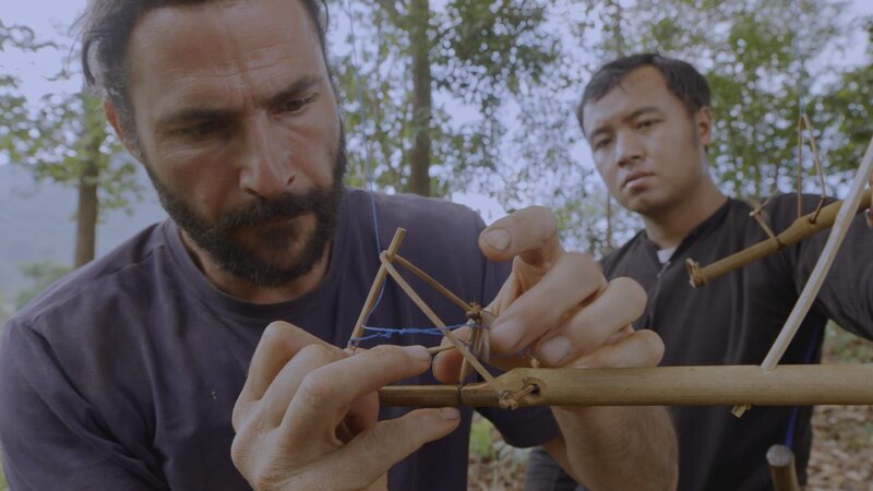 Hazen making a bird trap using a termite as bait. (National Geographic/​Alex Holden) – Bild: Alex Holden /​ National Geographic